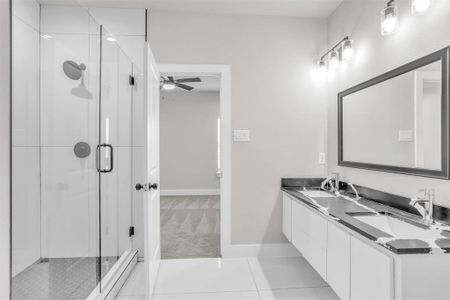 Bathroom featuring a shower with door, vanity, ceiling fan, and tile patterned flooring