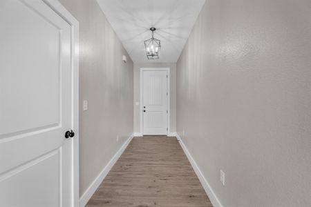 Hall with a notable chandelier and light hardwood / wood-style flooring