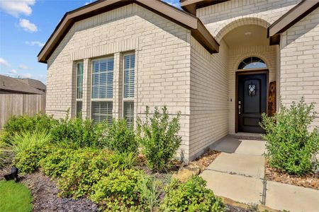 CHARMING FRONT PORCH ACCENTED BY PROFESSIONAL LANDSCAPING WELCOMES YOUR GUESTS.