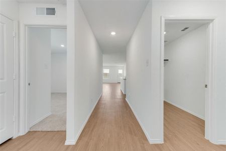 Hallway with light hardwood / wood-style flooring