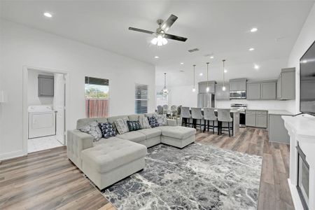 Living room featuring washer / dryer, ceiling fan, and hardwood / wood-style flooring