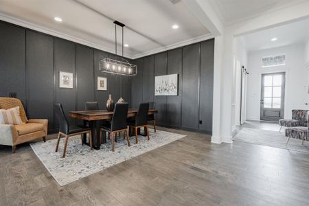 Dining space featuring ornamental molding, hardwood / wood-style floors, and a barn door