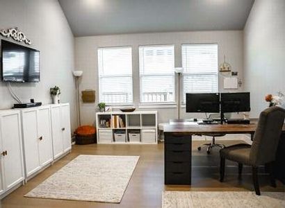 Home office featuring lofted ceiling and light hardwood / wood-style floors