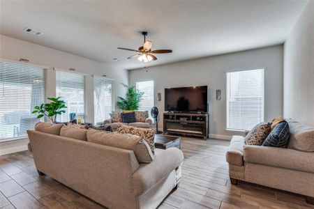 Living room with ceiling fan and light hardwood / wood-style floors