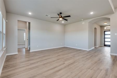 Empty room with light hardwood / wood-style floors and ceiling fan