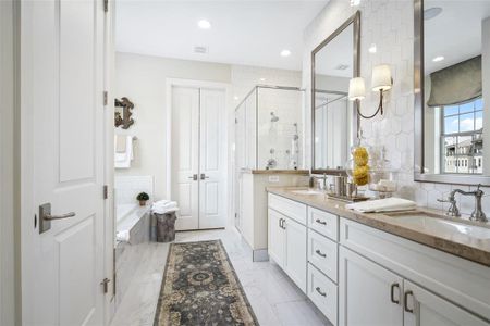 Equipped with double sinks, glass-door shower, and built-in soaking tub, the Primary Bathroom offers complete relaxation while remaining highly functional. Photo is of an existing home & used for representative purposes only.