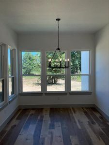 Unfurnished dining area featuring a notable chandelier and hardwood / wood-style flooring