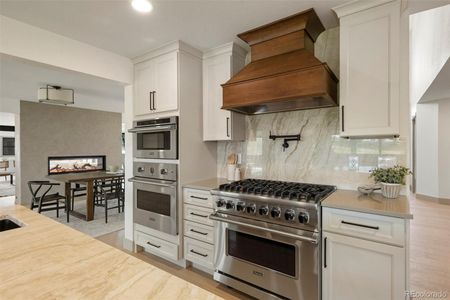 Viking applainces and custom maple hood with a Brazilian quartzite island counter and backsplash.