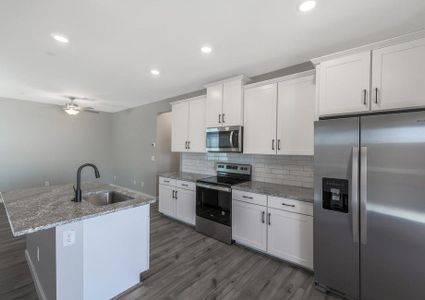 Chef-ready kitchen with white cabinets, stainless steel appliances, and granite countertops.