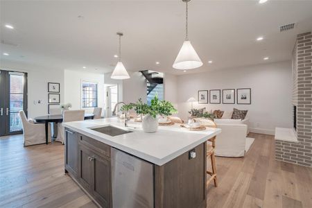 Kitchen with Sub Zero fridge, Wolf range stove, marble backsplash, 2 inch thick quartz countertops, and an island with sink.