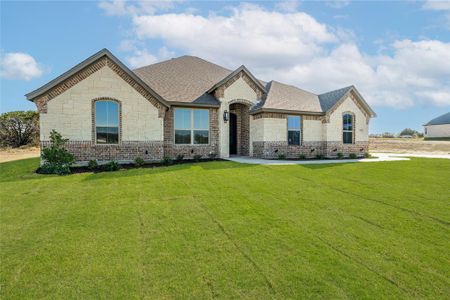 French country inspired facade featuring a front yard and a patio