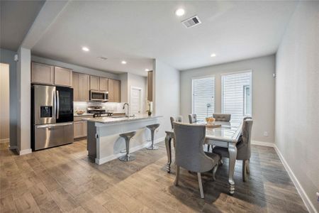 Modern open-concept kitchen with stainless steel appliances, ample cabinetry, and an adjoining dining area with plenty of natural light.