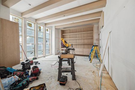 Off the entrance of the home is a Formal Library with Floor to Ceiling Windows, Beamed Ceiling, Built-In Shelves, Drawers and More...