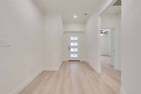 Entrance foyer featuring light hardwood / wood-style flooring, ornamental molding, and ceiling fan