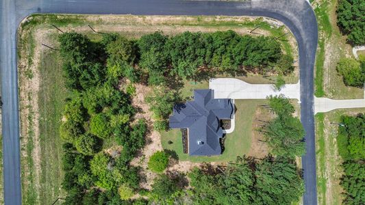 Discover serene living with this charming home nestled on 1.5 acres, boasting a generous yard, private driveway, and an elegant dark roof, all set against a backdrop of lush greenery along a graceful, winding road.