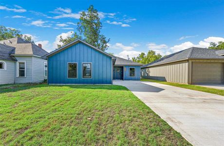 View of front of property with a garage and a front lawn