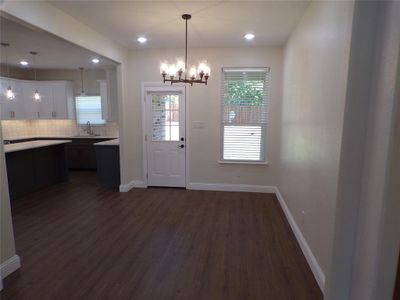 Foyer entrance with dark wood-type flooring, sink, and an inviting chandelier