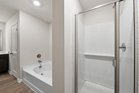 Bathroom featuring vanity, hardwood / wood-style floors, and shower with separate bathtub