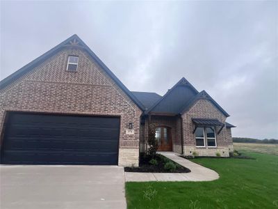 View of front facade featuring a front lawn and a garage