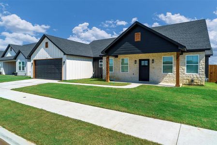 View of front of property with a front yard and a garage