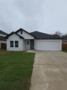 Ranch-style home featuring a garage and a front lawn