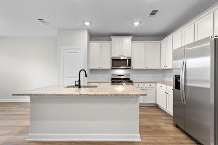 In this kitchen, white cabinets exude a sense of freshness and purity, perfectly paired with the luminous beauty of granite countertops. The open layout fosters a welcoming atmosphere, inviting conversation and interaction between the kitchen and living area