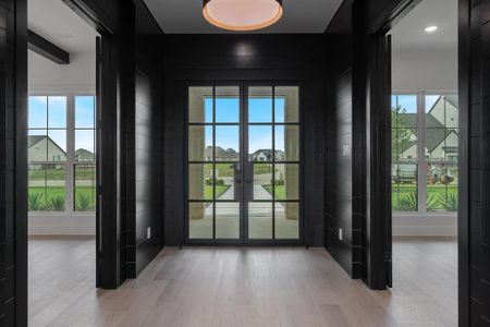 Doorway to outside with plenty of natural light, french doors, and light wood-type flooring