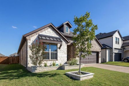 View of front of property with a garage and a front lawn