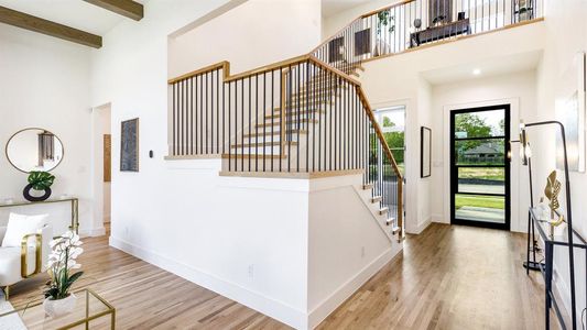 Entrance foyer featuring beamed ceiling, hardwood / wood-style floors, and a towering ceiling