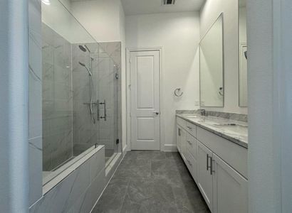 Luxurious primary bathroom with dual sinks and stand alone shower