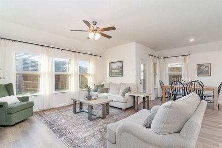 Living room with ceiling fan, plenty of natural light, and light wood-type flooring