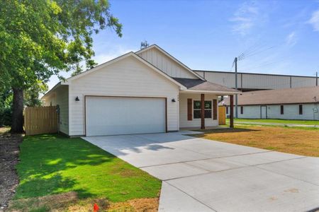 Ranch-style house featuring a garage and a front lawn