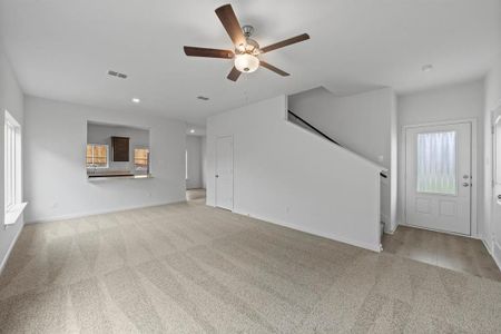 Living room with ceiling fan and light colored carpet