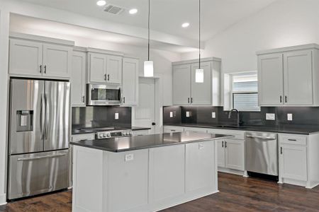 Kitchen with sink, appliances with stainless steel finishes, dark hardwood / wood-style floors, and backsplash