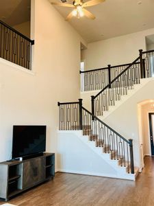 Living ro0m with high ceilings and staircase with modern iron spindles.