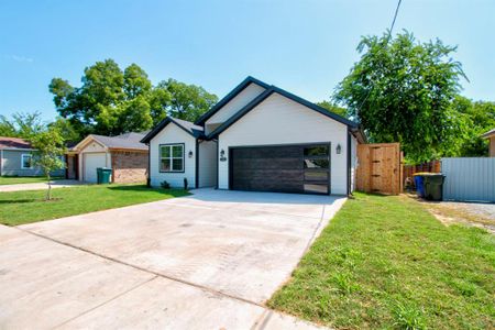 Ranch-style house with a garage and a front lawn