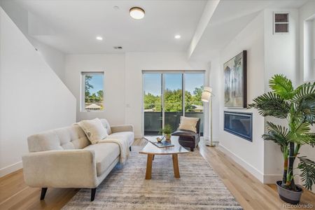 Casual Open Concept Floor Plan. Living Room with Cozy Gas Fireplace, Hardwood Flooring and Access to Covered Outdoor Balcony/Deck.