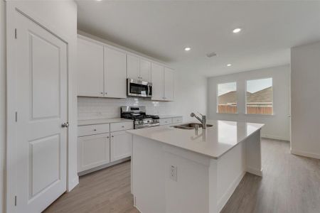 Kitchen featuring sink, appliances with stainless steel finishes, and white cabinets