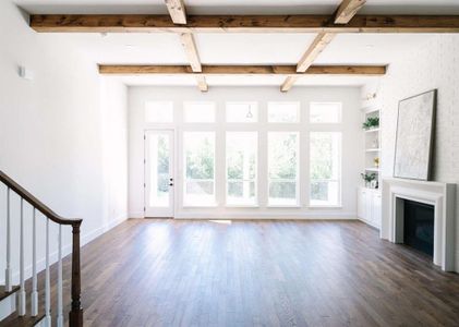 Unfurnished living room with beamed ceiling and dark hardwood / wood-style flooring