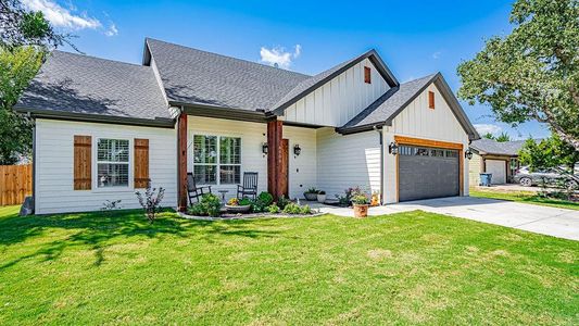 View of front of property featuring a front yard and a garage