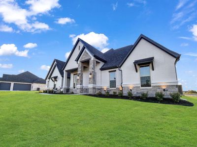 View of front of property with a garage and a front yard