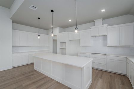 Kitchen featuring a kitchen island and white cabinetry