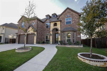 View of front facade featuring a front yard and a garage