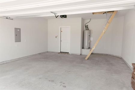 Garage with electric water heater, a garage door opener, and electric panel