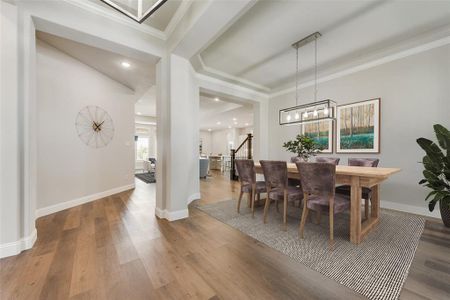 Dining area with wood-type flooring and crown molding