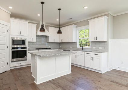 Angled shot of the kitchen with granite countertops and white cabinets.