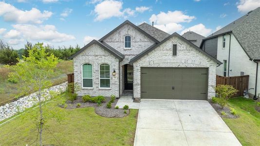 French country style house featuring a garage and a front yard