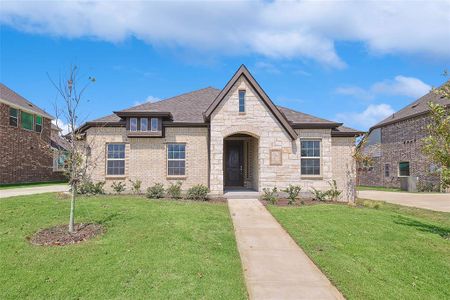 French country inspired facade with a front yard