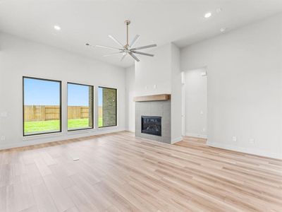Family Room with Luxury Vinyl Plank Flooring, Modern Ceiling Fan, and Floor Outlet.