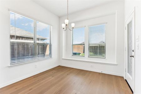 Unfurnished dining area featuring a notable chandelier and light hardwood / wood-style flooring